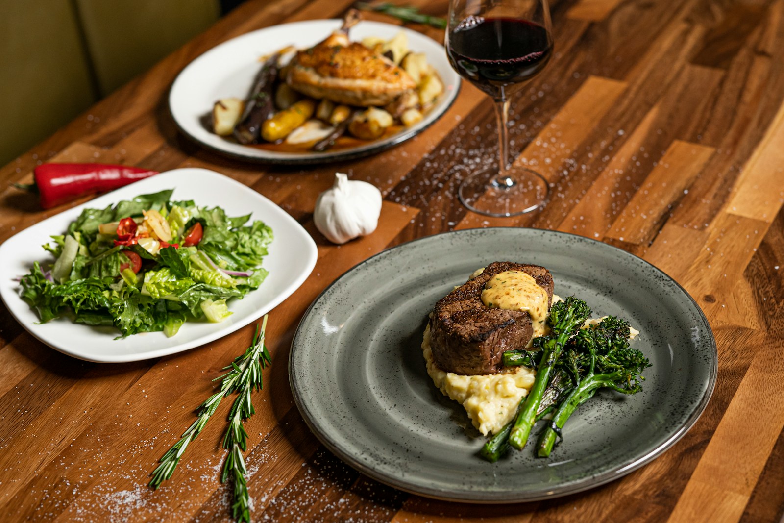 A restaurant table set with plated food and wine