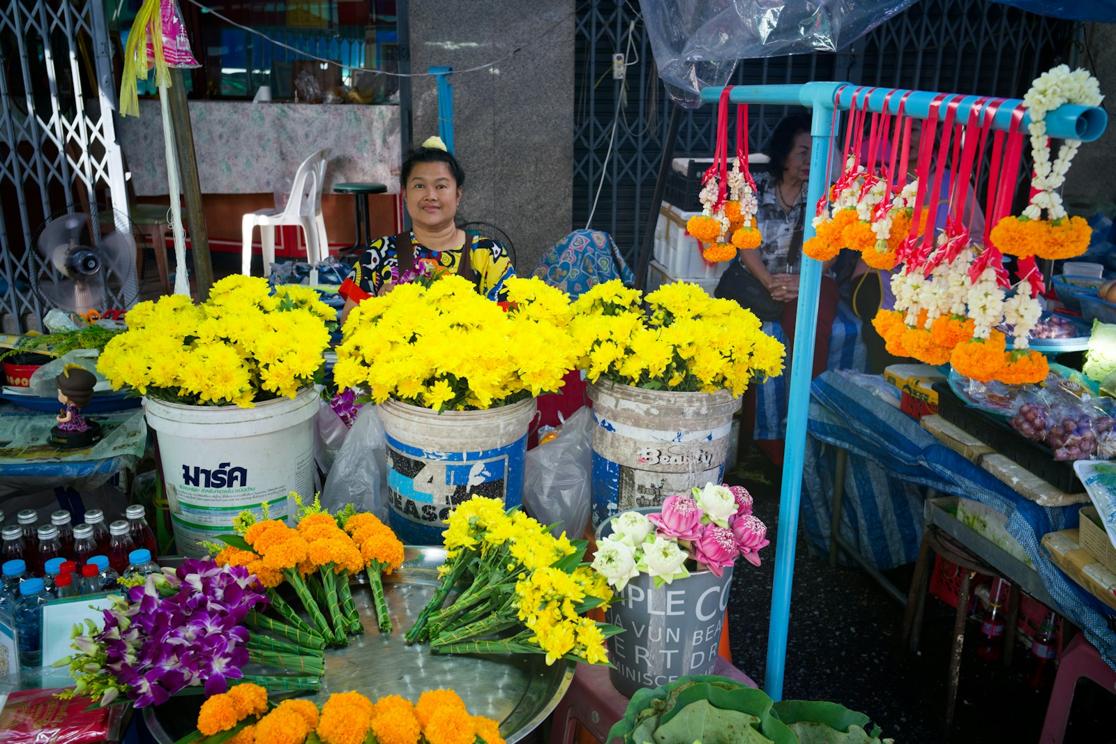 A vendor selling colorful flowers and garlands at a market stall