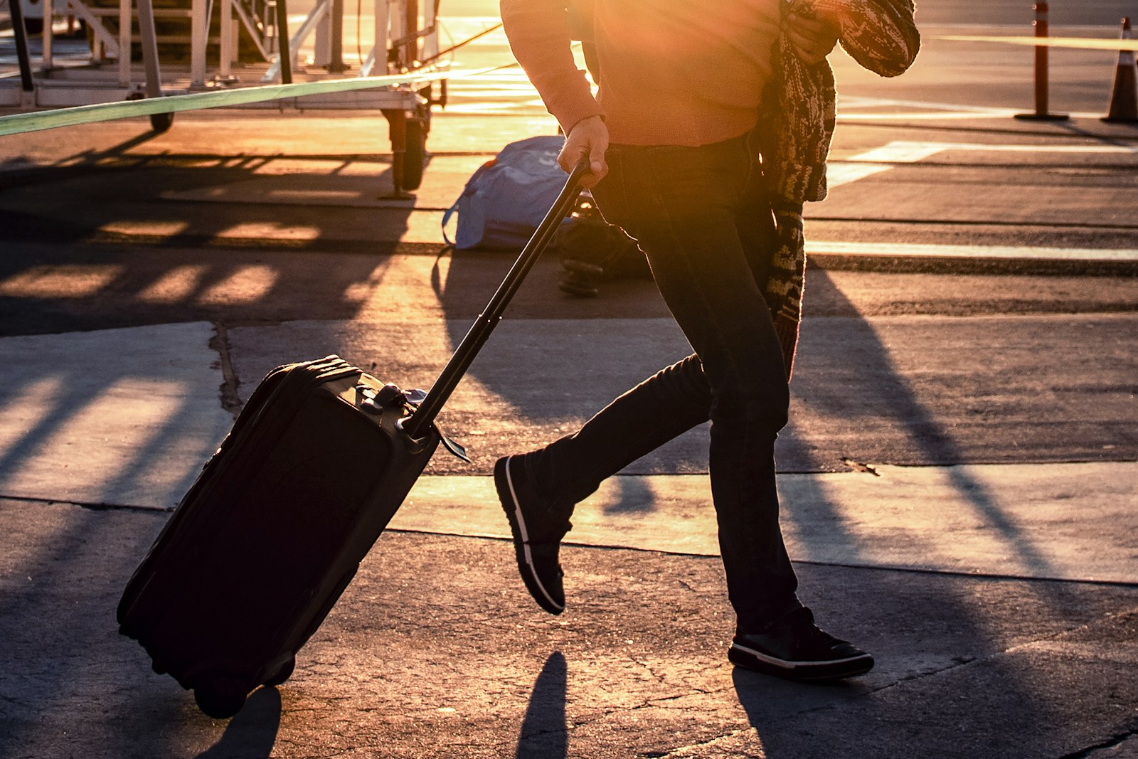 A traveler walking through an airport terminal with luggage